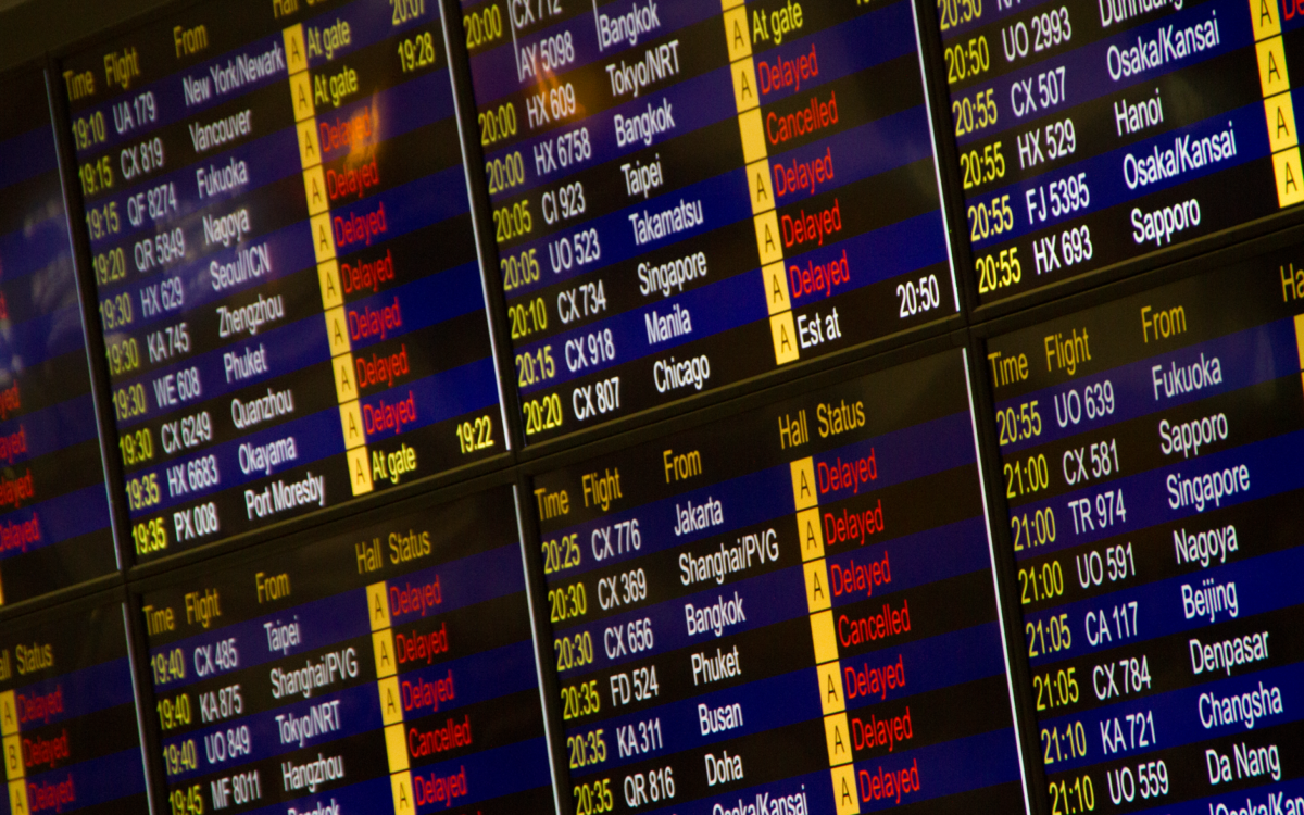 Detalhe de painel digital de informações de voos mostrando chegadas e partidas em um aeroporto