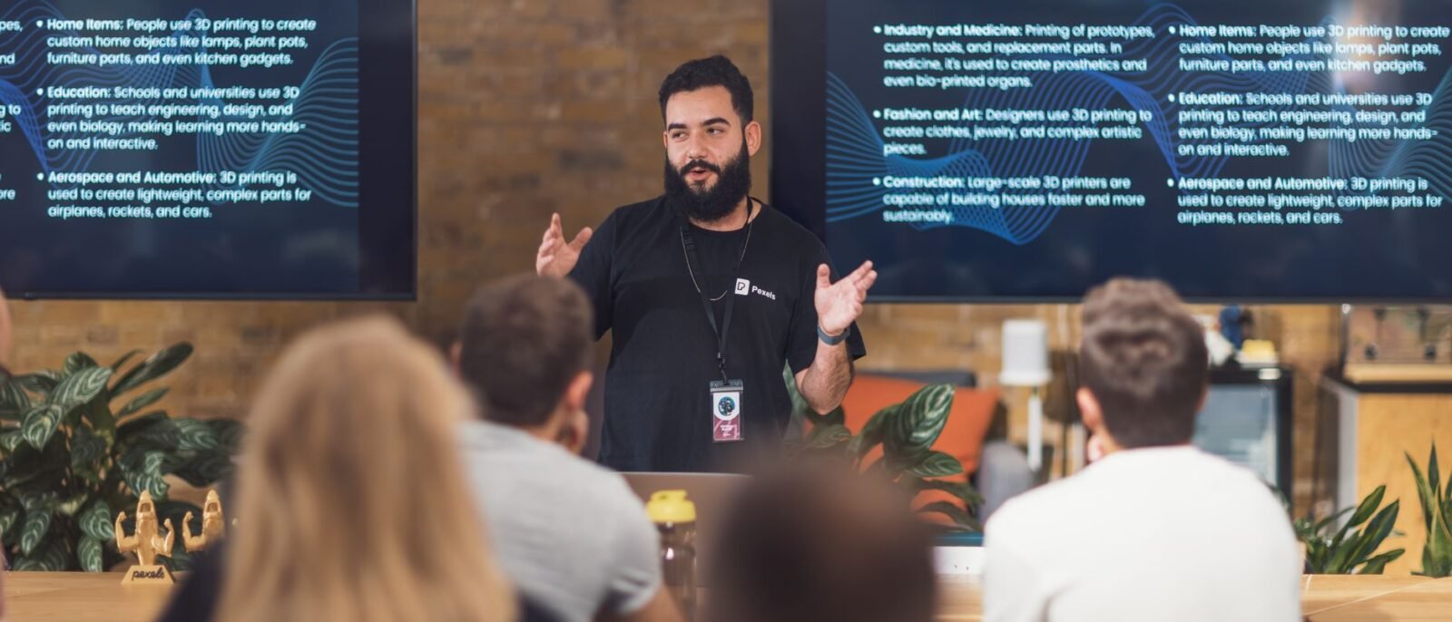 Palestrante profissional discute aplicações de impressão 3D com público atento em seminário de tecnologia