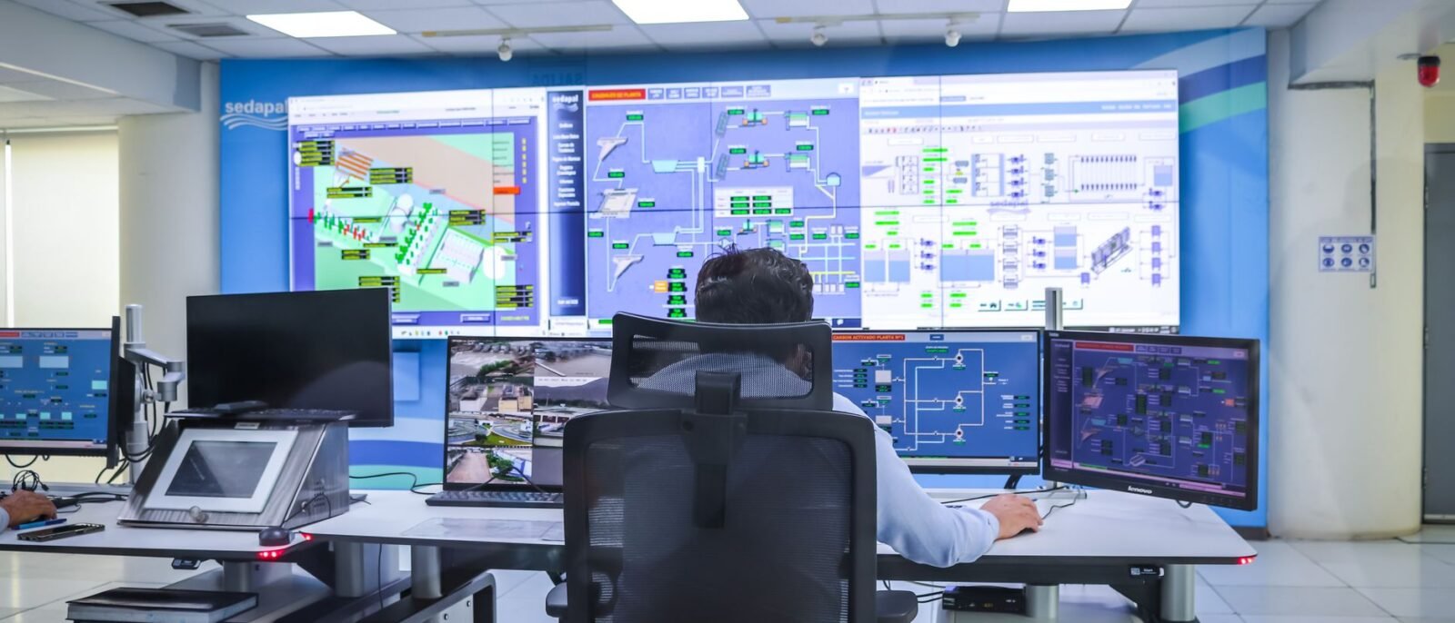 Operador em uma sala de controle moderna gerenciando sistemas tecnológicos em El Agustino, Lima