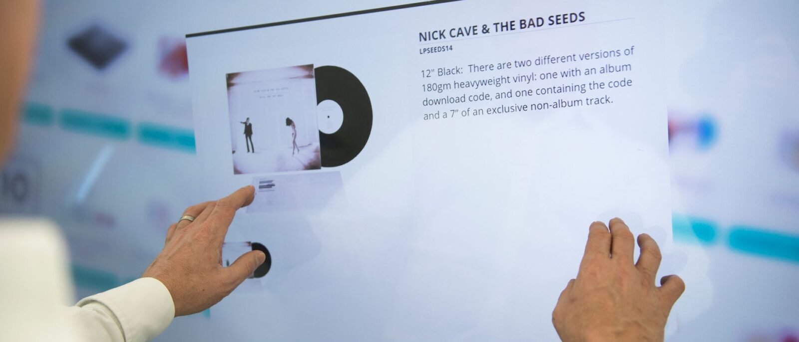Uma pessoa usando uma tela sensível ao toque para procurar informações de vinil do Nick Cave & The Bad Seeds